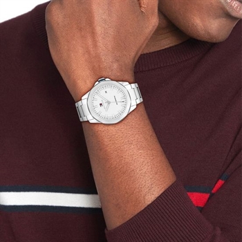 En mand bærer et sølvfarvet Tommy Hilfiger Lars Automatic ur på sit venstre håndled. Han er iført en bordeauxfarvet sweater.
